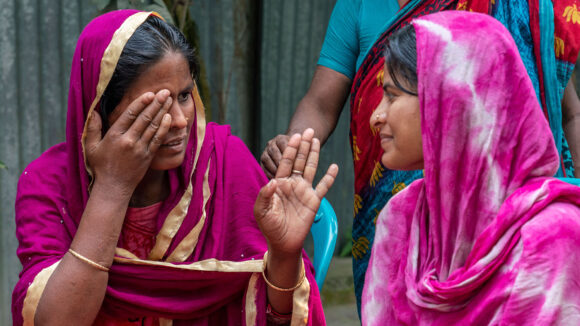 Munina communicates with Shamima using hand gestures.