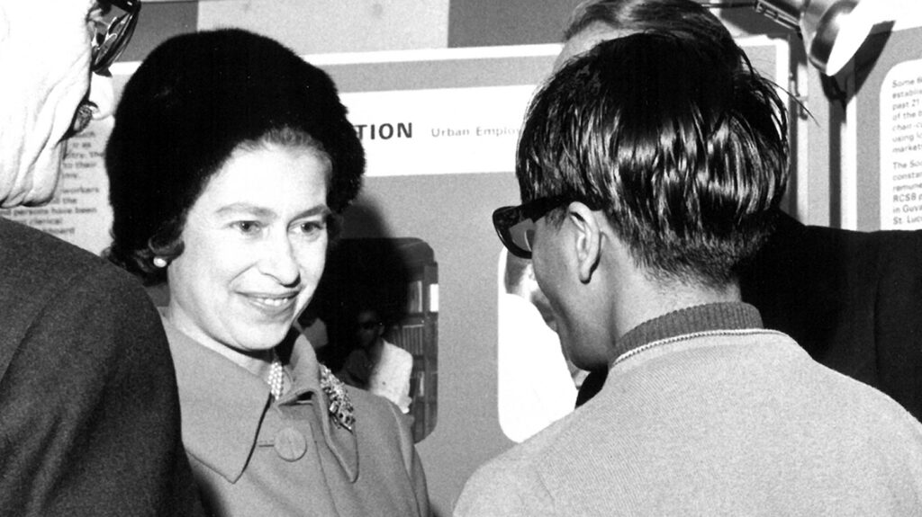 The Queen smiles as she greets staff.