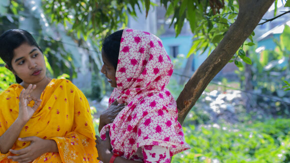 Two women communicate using sign language.