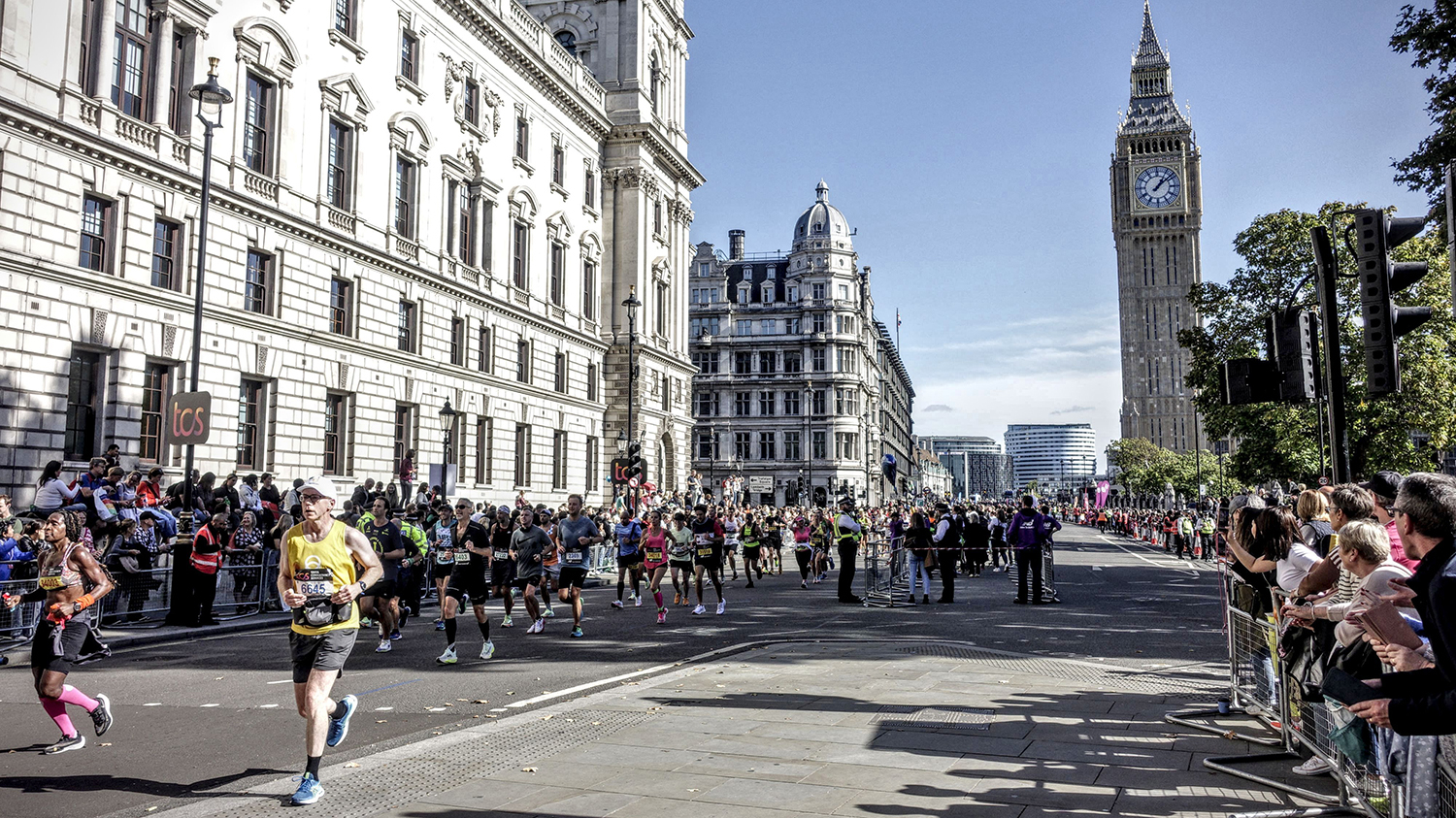 Athletes run down the streets of London with Big Ben in the background.