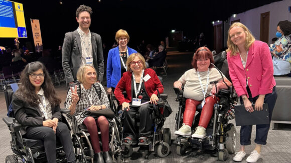 A group of seven people, four of whom are wheelchair users.