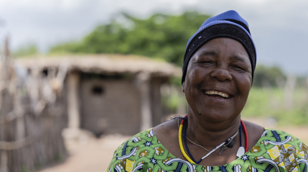 Cataract patient Holo smiles while standing outside her home.