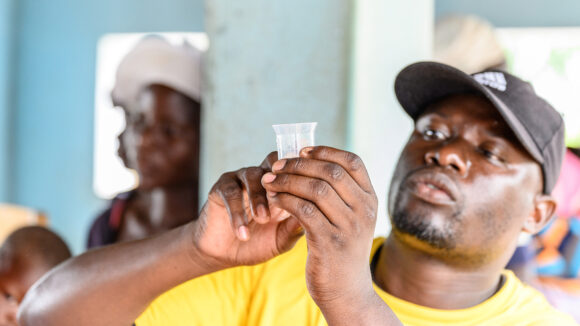 Ndumiso Ndlovu, an Ophthalmic nurse, measures medicine as part of mass drug administration in Zimbabwe