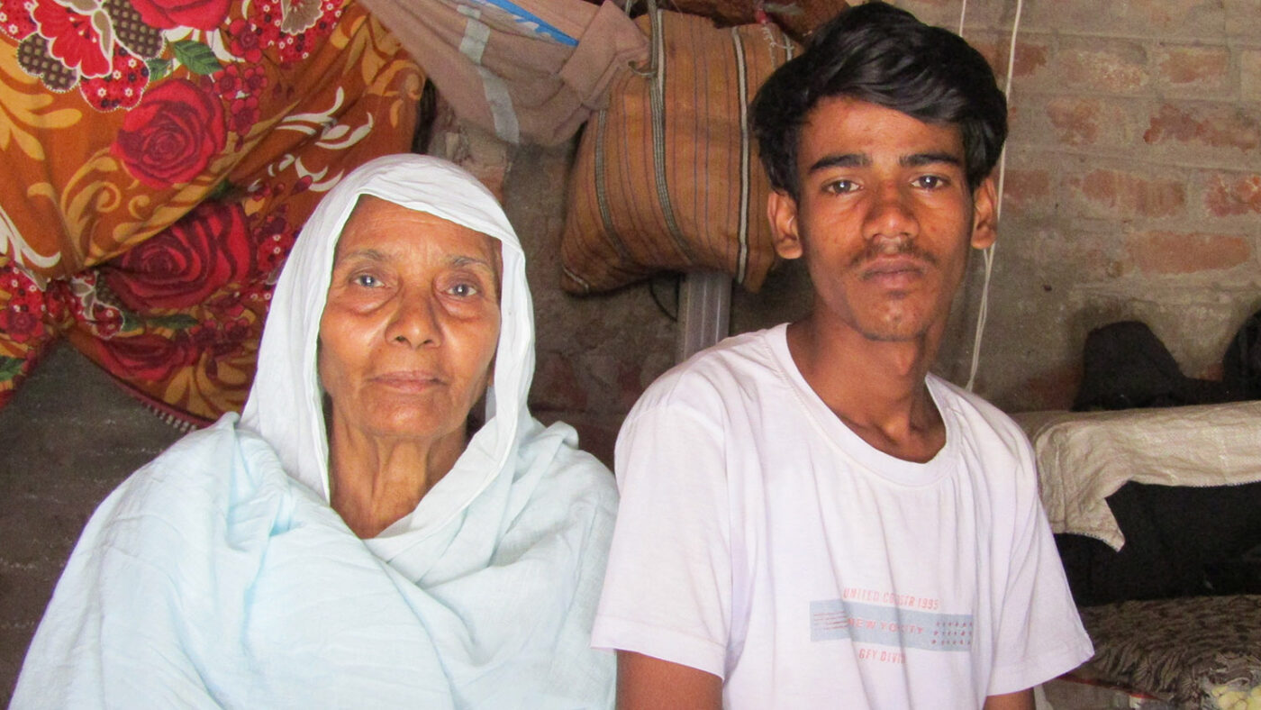 Shahid sits with his Grandma, looking to camera.