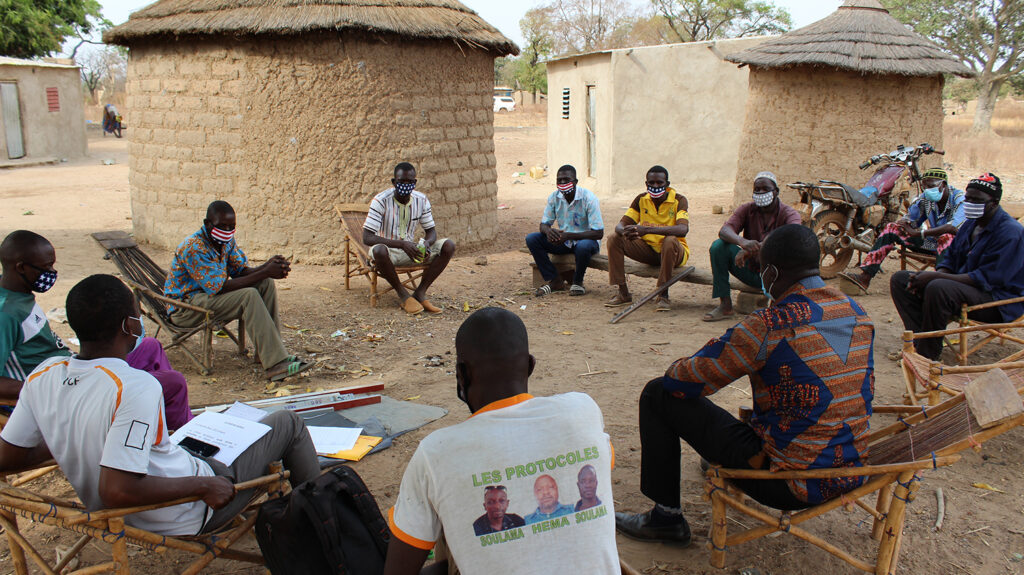 Community drug distributors gather in a circle at a meeting in Burkina Faso.