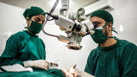 Two surgeons in an operating room perform a cataract operation.