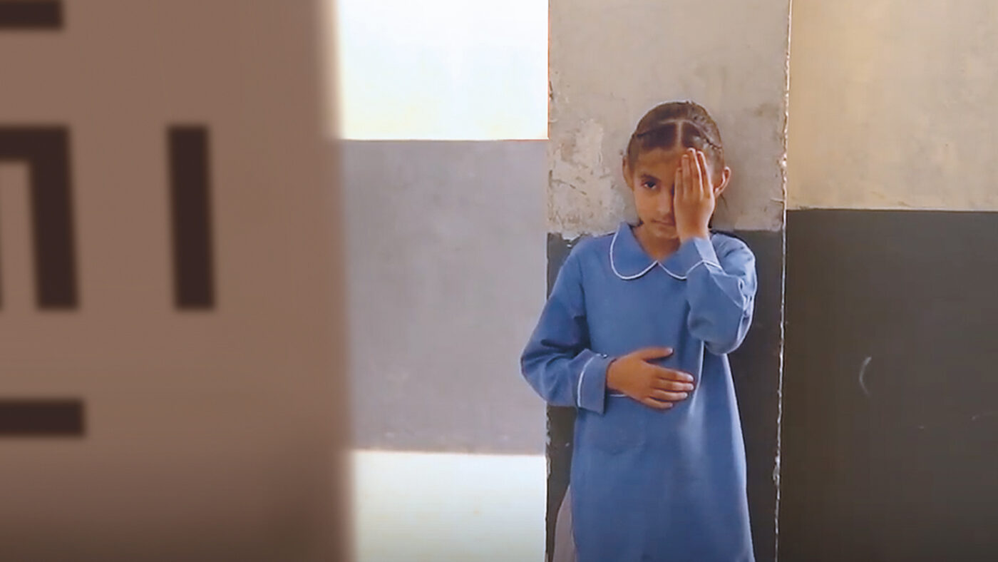 Nayab, a nine-year-old girl from Pakistan, taking an eye test at school.
