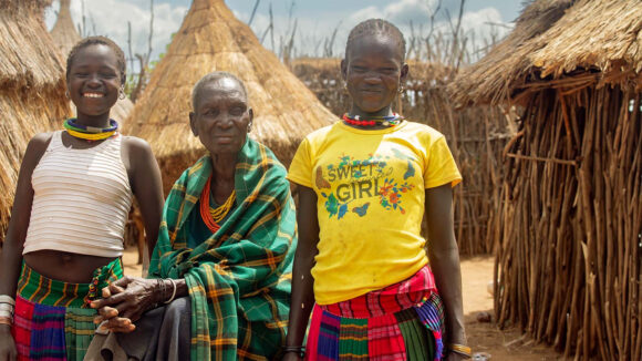 Nyangan and her granddaughters standing outside their home in Turkana, Kenya.
