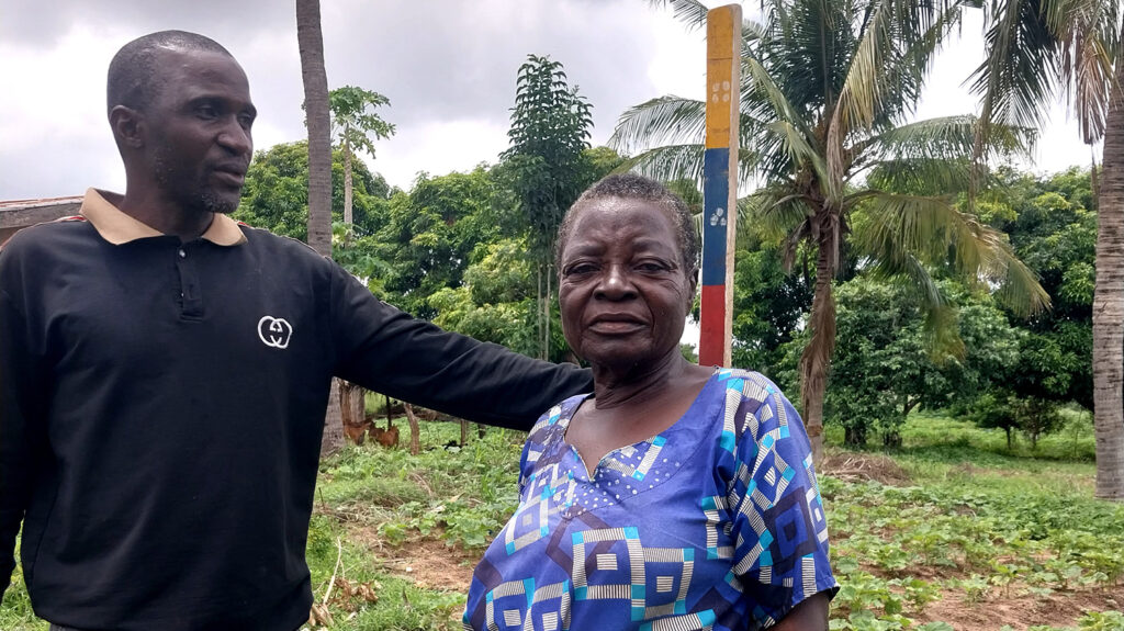 Volunteer Moses measures a woman's height to see how much medication she needs to protect her from river blindness.