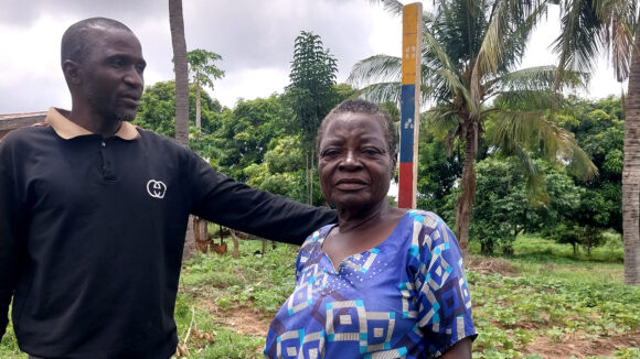 Volunteer Moses measures a woman's height to see how much medication she needs to protect her from river blindness.