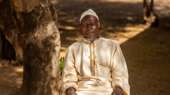 Sabane sits under a tree after successful surgery to treat hydrocele, caused by lymphatic filariasis.