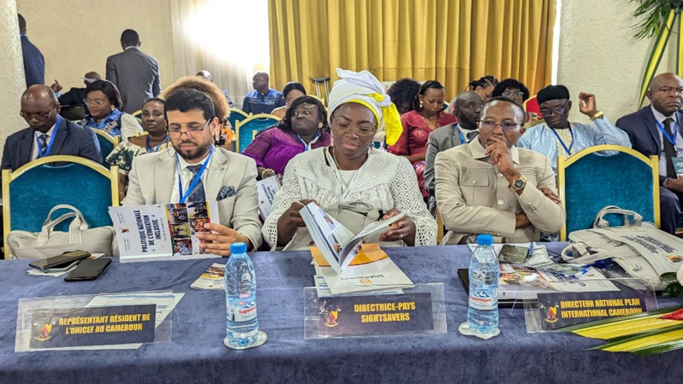 Three partners sit at a table with table name badges in front of them.