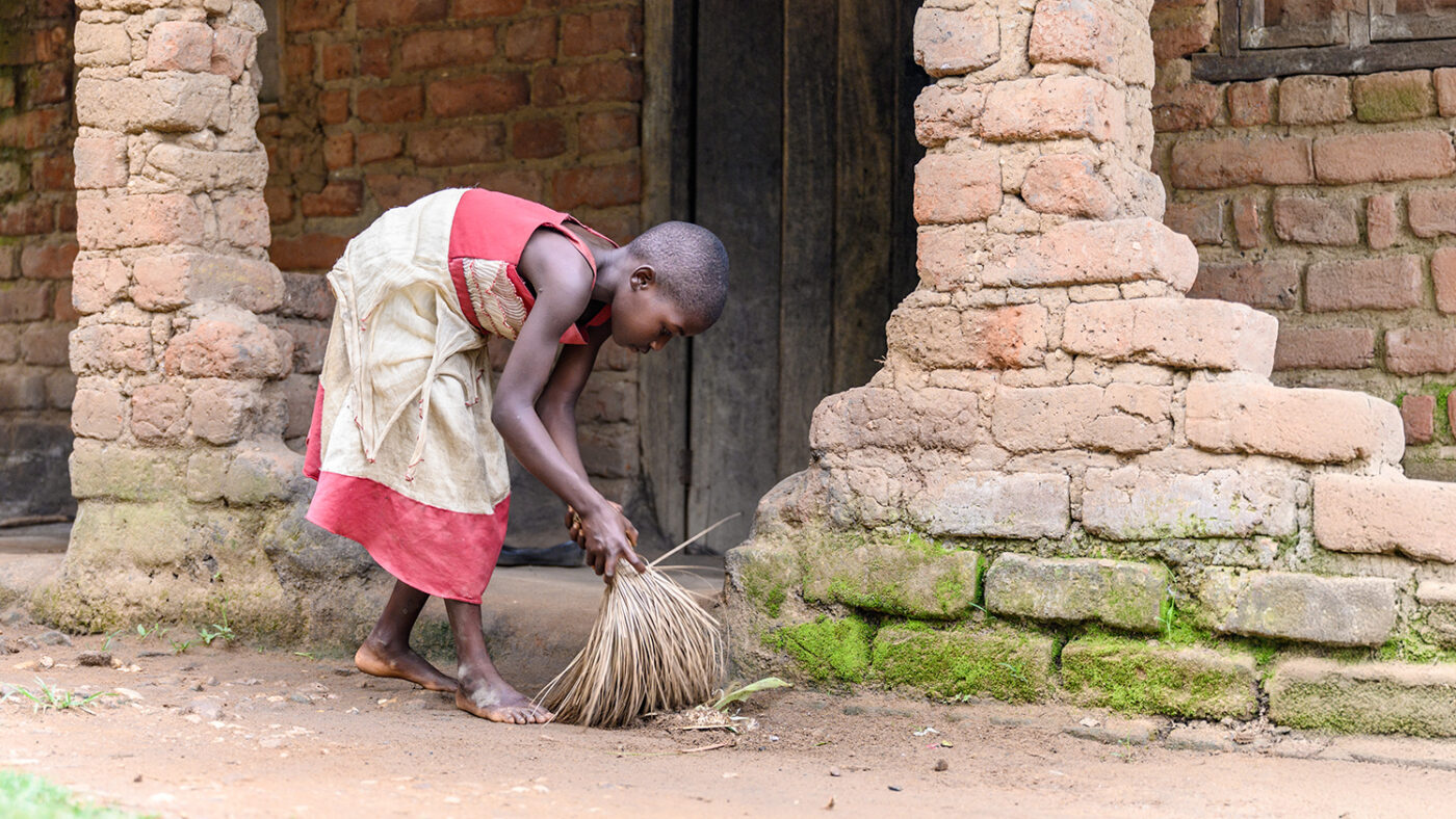 Mary sweeps the floor outside her home.