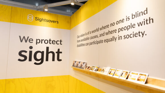 A wall featuring Sightsavers branding.
