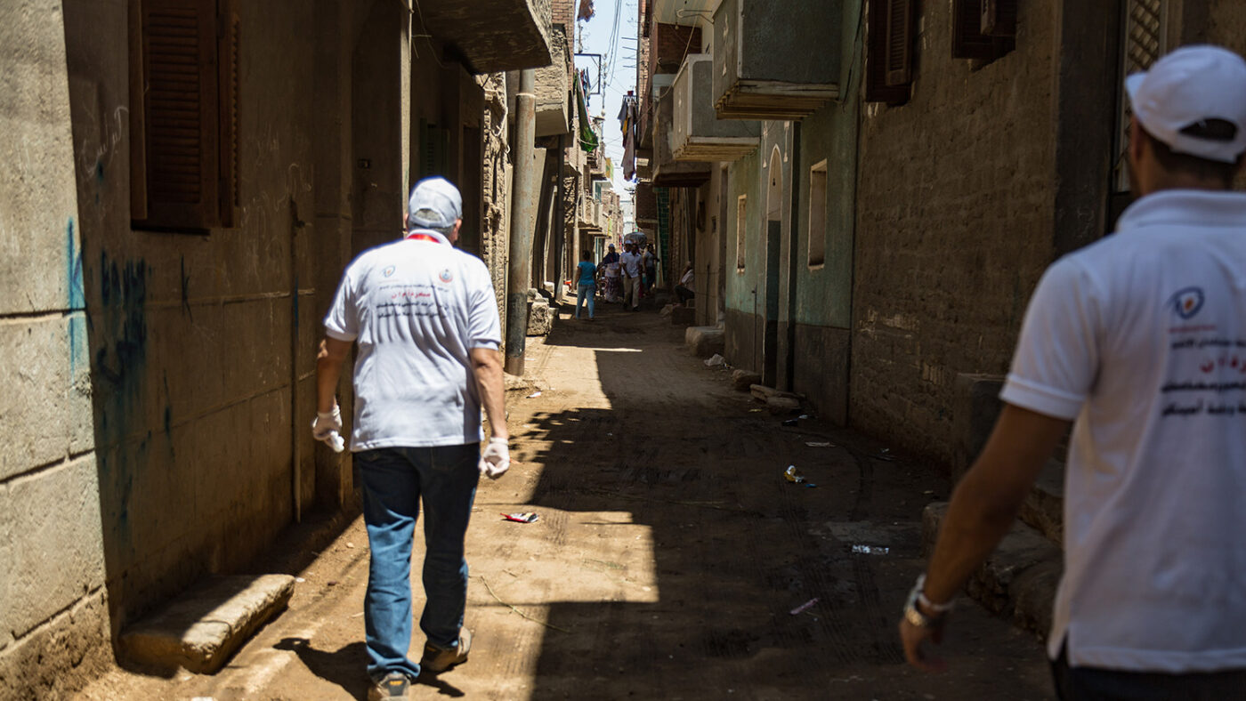 Two health care workers walk through the streets during a mass drug administration campaign for trachoma in Egypt.