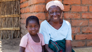 Achiwa sits outside her home with her great granddaughter Shameem.