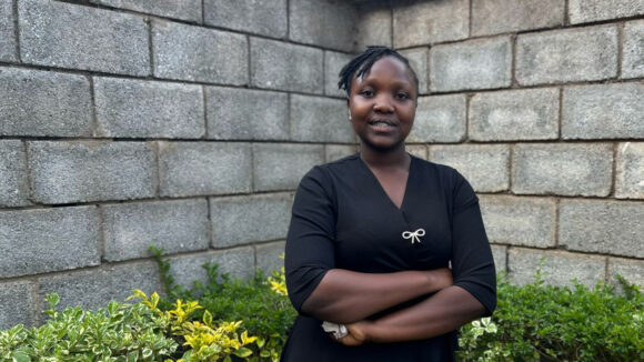 IT Bridge Academy graduate Lyne stands with her arms crossed.