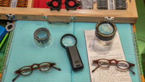 A table with spectacles and eye testing equipment on top.