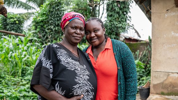 An older woman and a younger woman embrace.