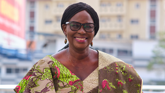 A woman with glasses smiles broadly.