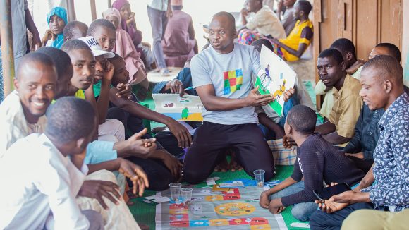 A course facilitator shows a group of men an illustration about family planning.