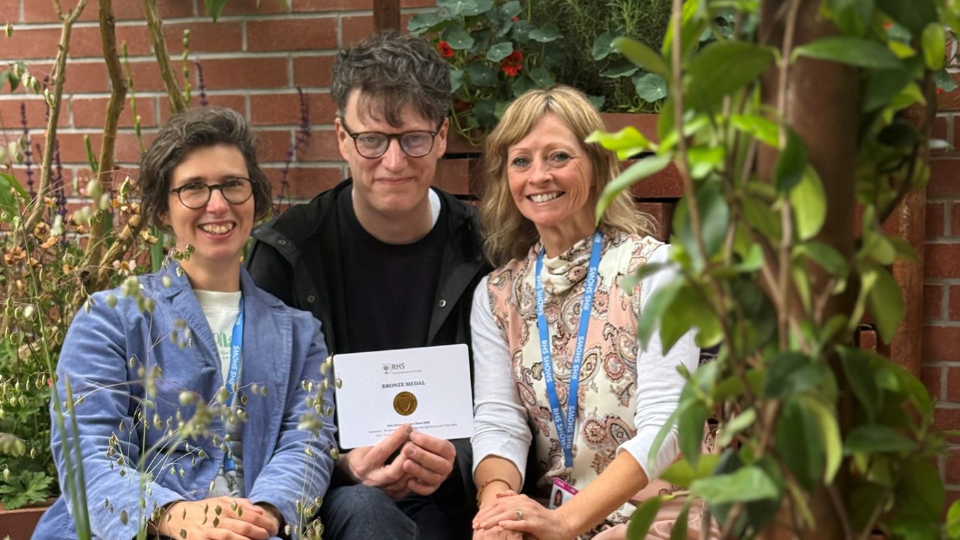 Sarah, Peter and Janice in the Sightsavers garden. Peter is holding an award certificate.