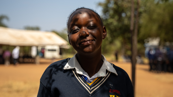 Dinah smiles in her school uniform.